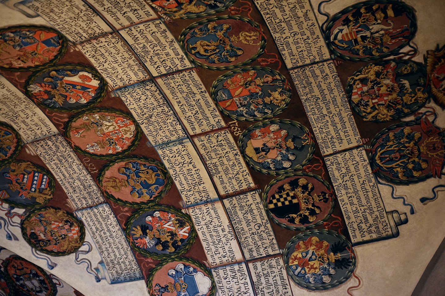 Documento antico decorato con stemmi storici colorati.