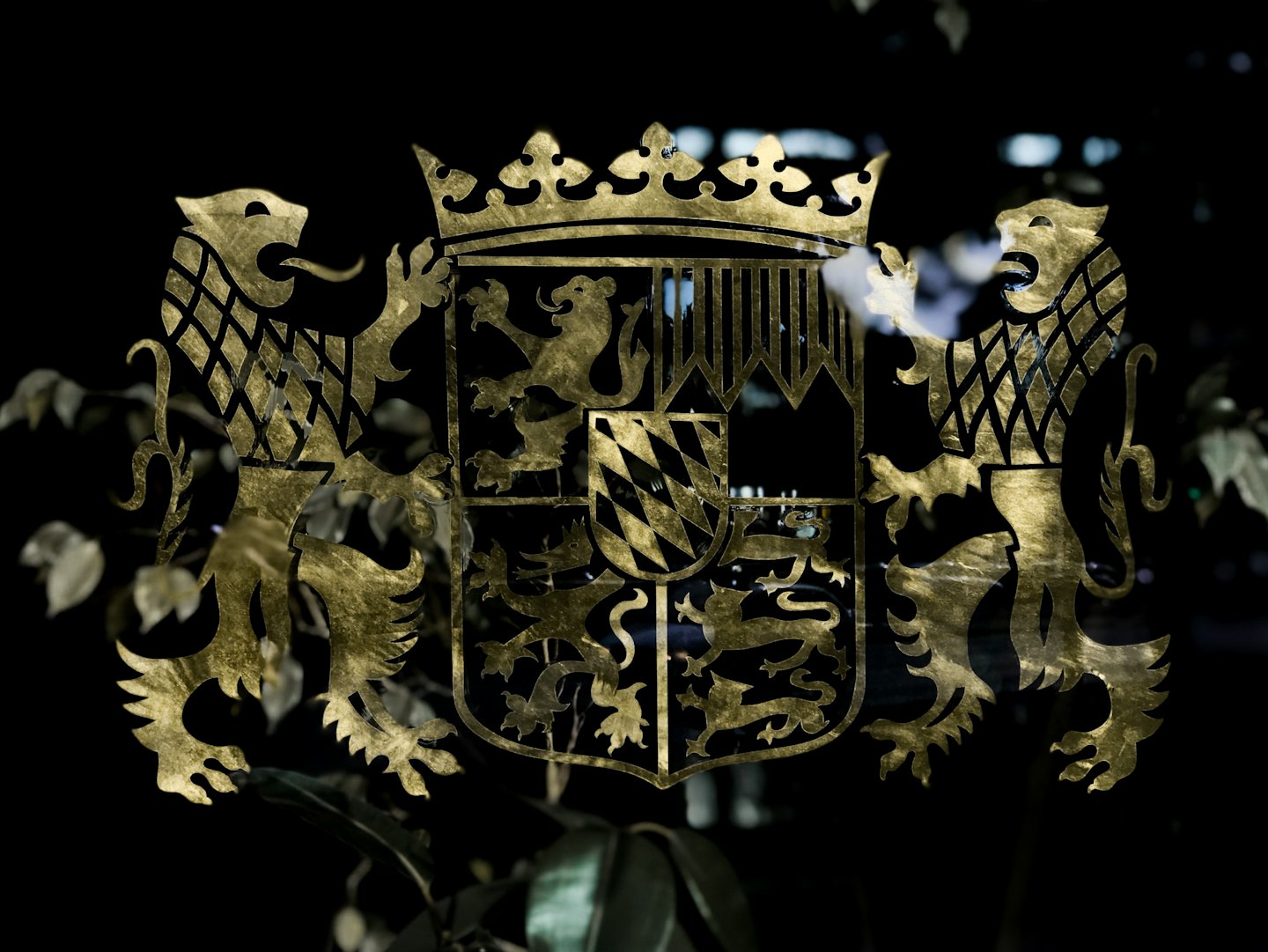 Un emblema araldico dorato con una corona e leoni rampanti.